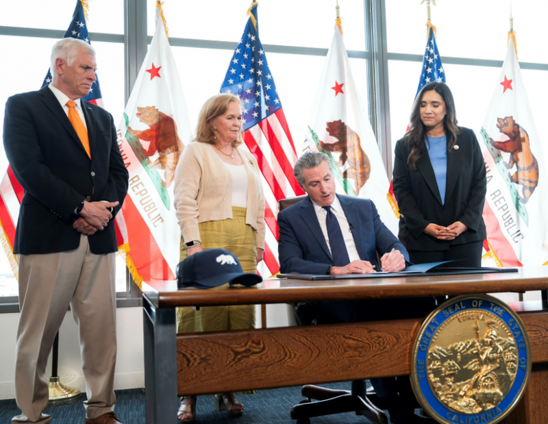 Senator Cervantes, right, looks on as Governor Gavin Newsom signes her landmark bill, SB 73.